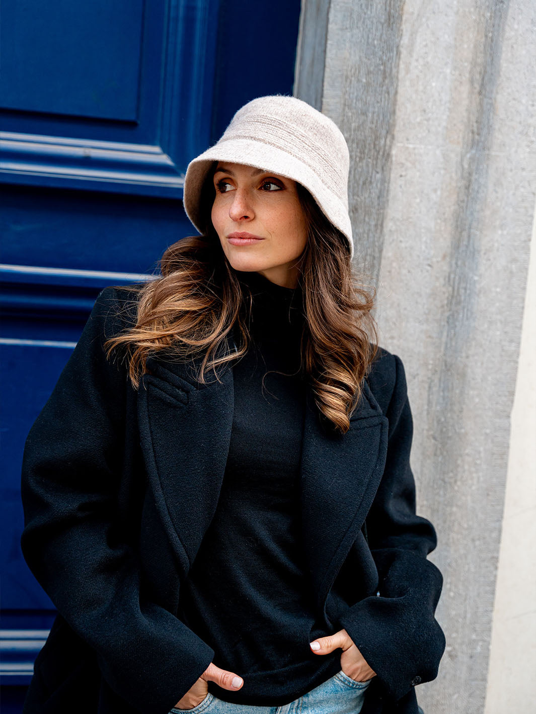 Frau mit LOEVENICH Glockenhut 672501 am Kopf hat die Hände in die Hosentaschen gesteckt und wartet