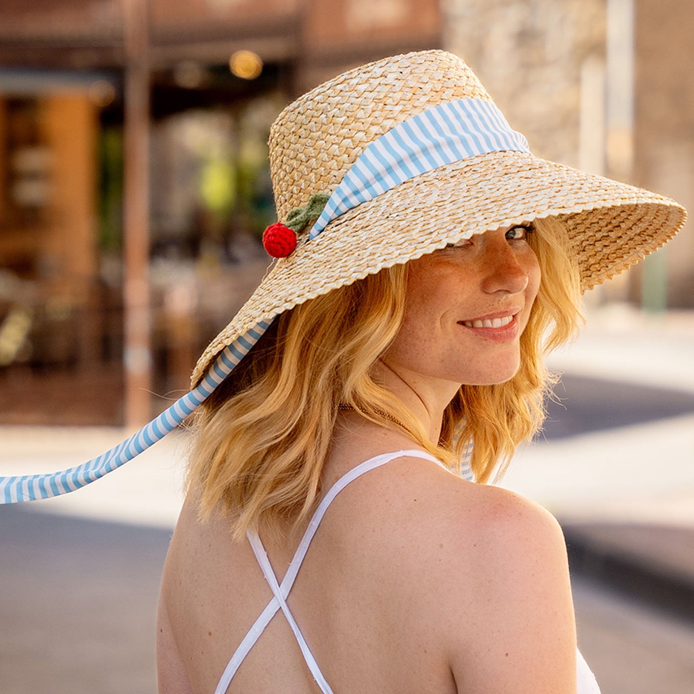 Frau trägt den Loevenich Strohhut mit gehäkelten Kirschen und Hutband
