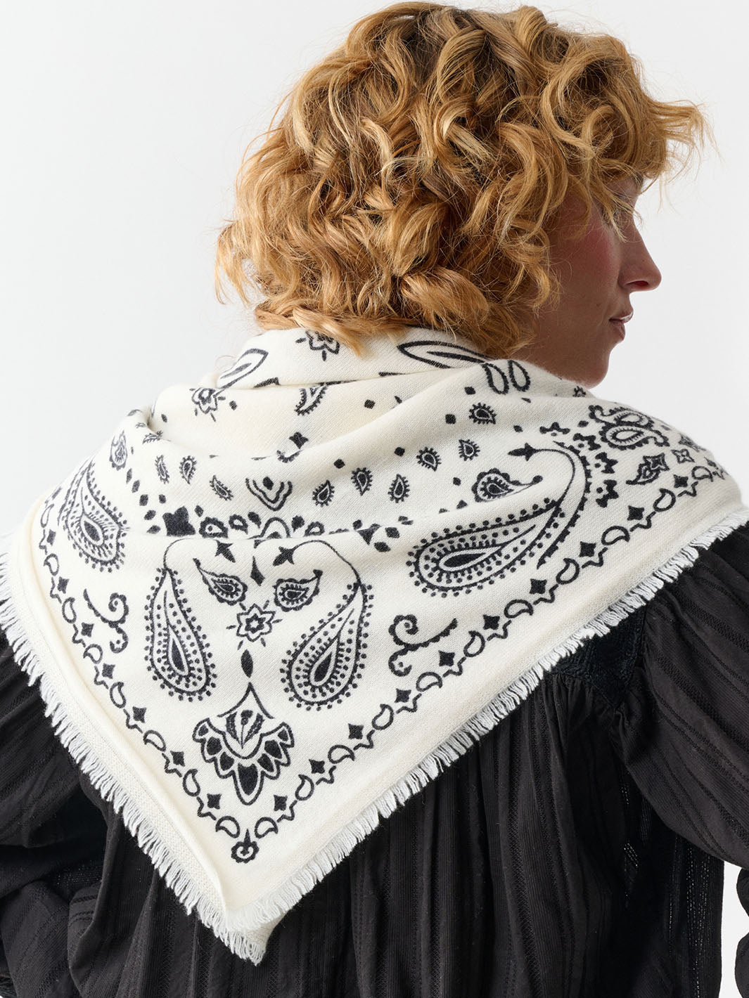 Frau mit Rücken zur Kamera trägt das Kaschmir-Tuch mit Paisley-Design 684331 als Schultertuch.