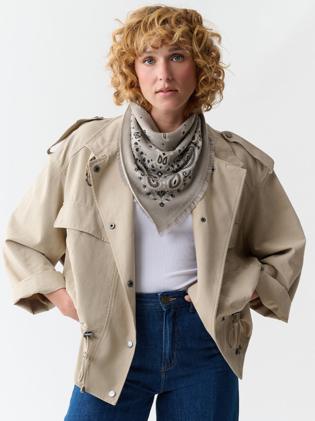Frau trägt Kaschmir-Nickituch mit Paisley-Design 6844330 um den Hals und hat die Hände in die Hüften gestemmt.