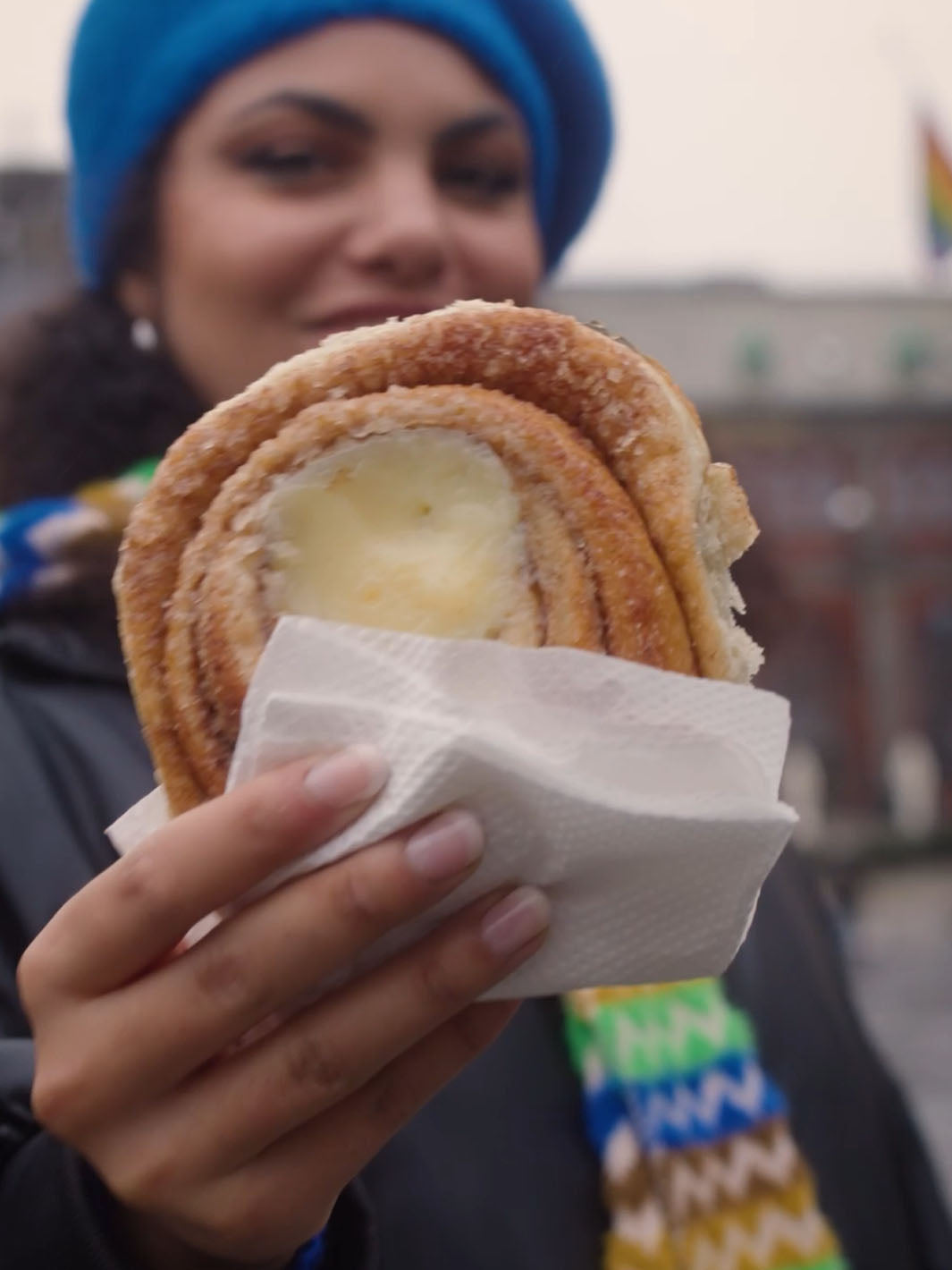 Frau hält Zimtschnecke in die Kamera