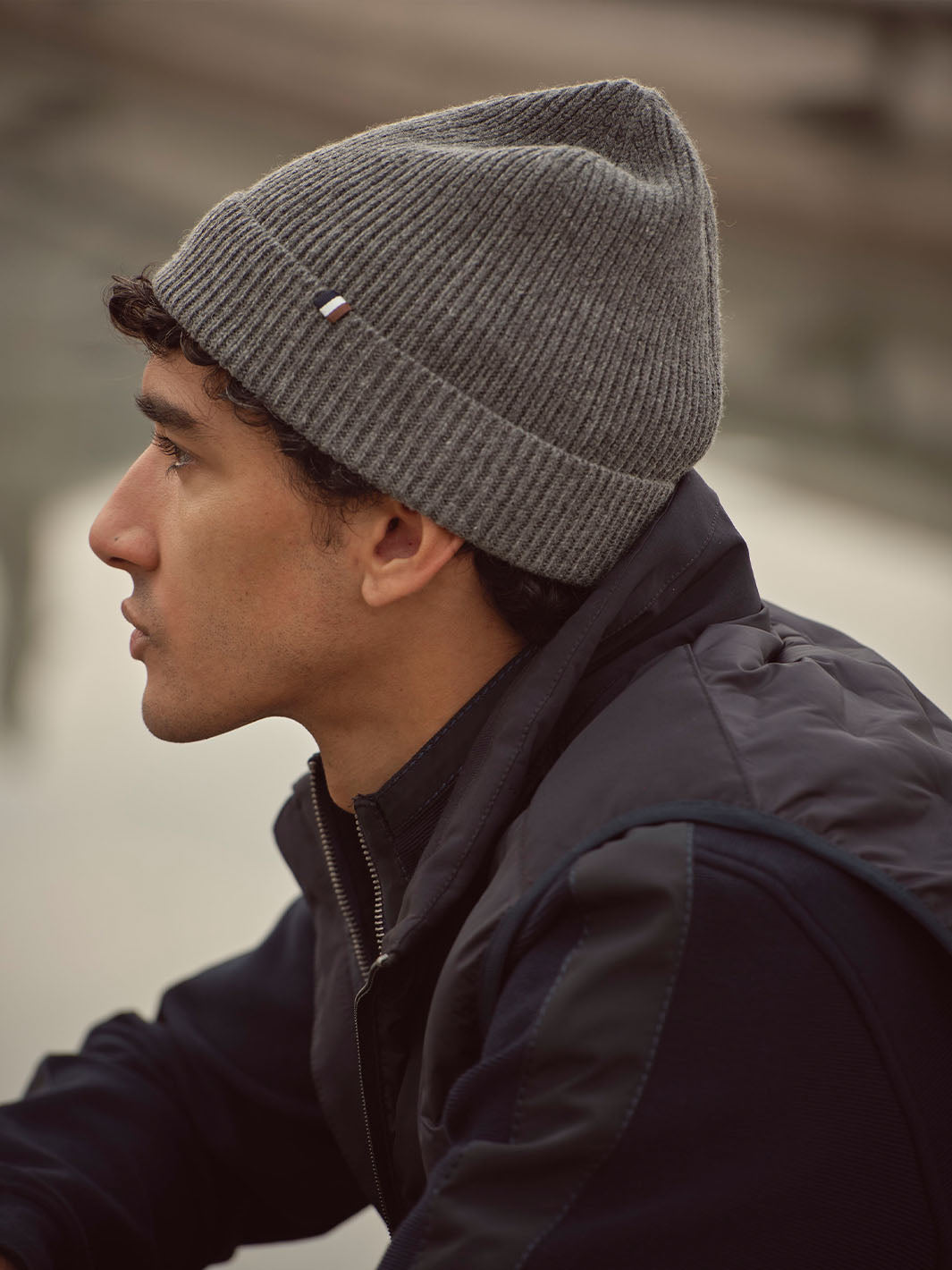 Seitliche Nahaufnahme eines Mannes mit bugatti-Strickmüzte am Kopf