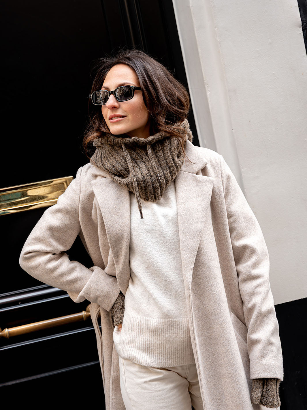 Frau präsentiert gestrickten Schal und Stulpen