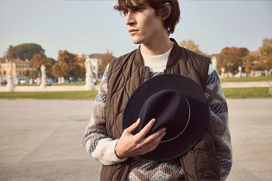 Mann hält sich den bugatti Fedora Hut 629017 vor die Brust