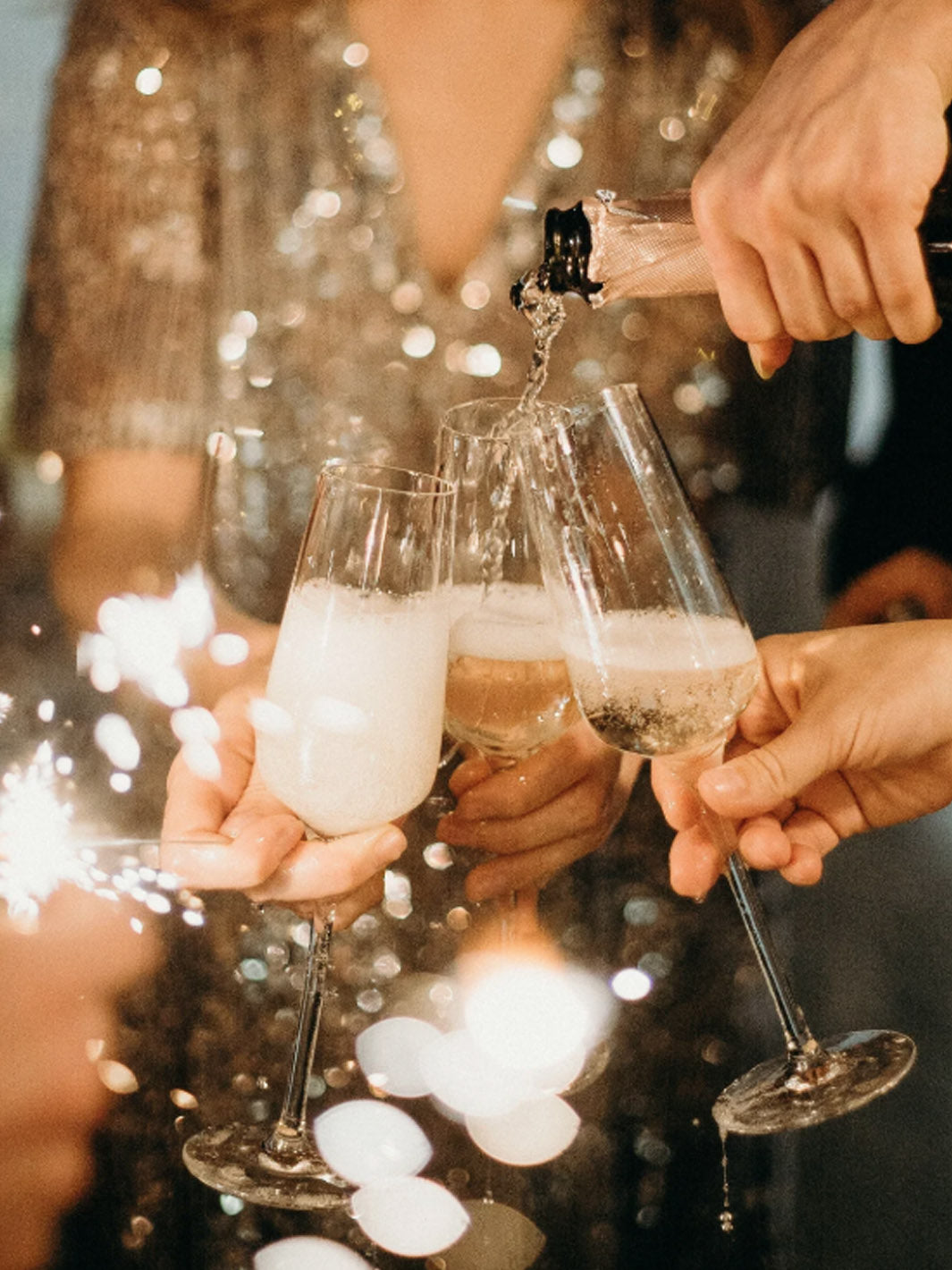 drei Sektgläser werden gefüllt