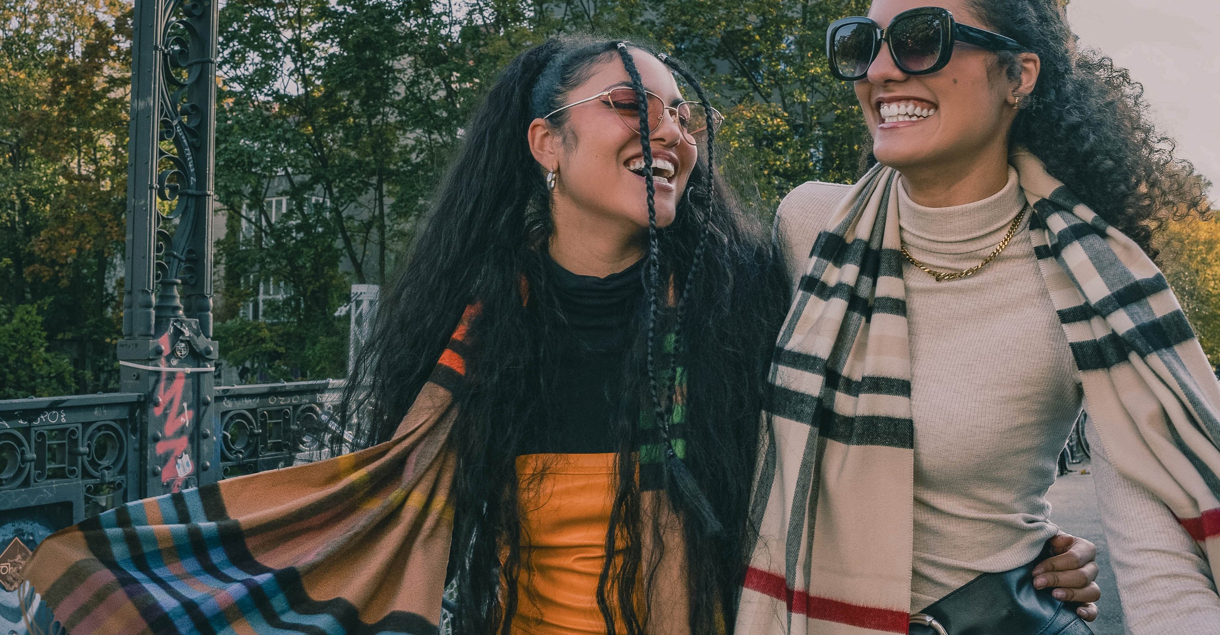 zwei lachende Frauen beim Spaziergang, beide mit einem Schal mit FRAAS Plaid Karo um den Hals