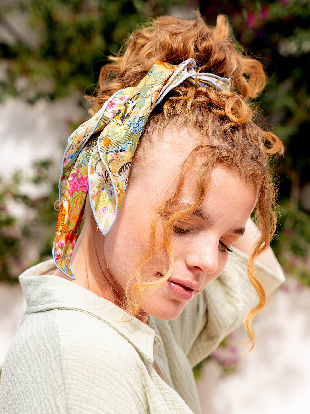 Frau hat sich das Seidentuch 612022 mit FRAAS Plaid Karo als Haarband ins Haar gebunden.