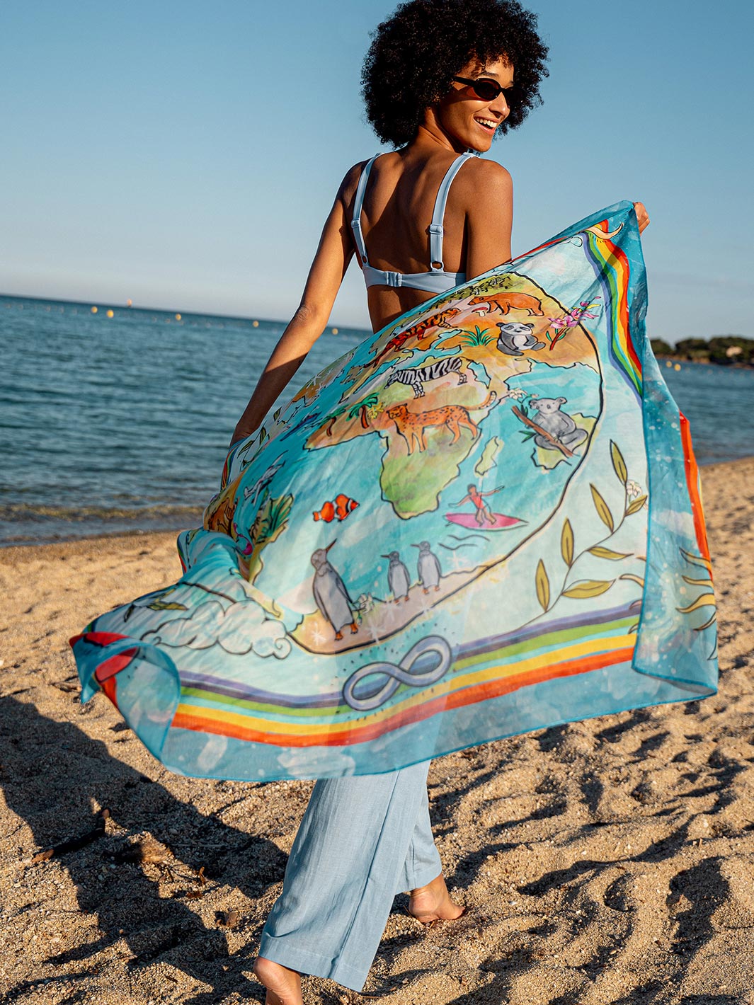 Frau läuft über den Strand und lässt das Seidentuch 633037 hinter sich im Wind flattern.