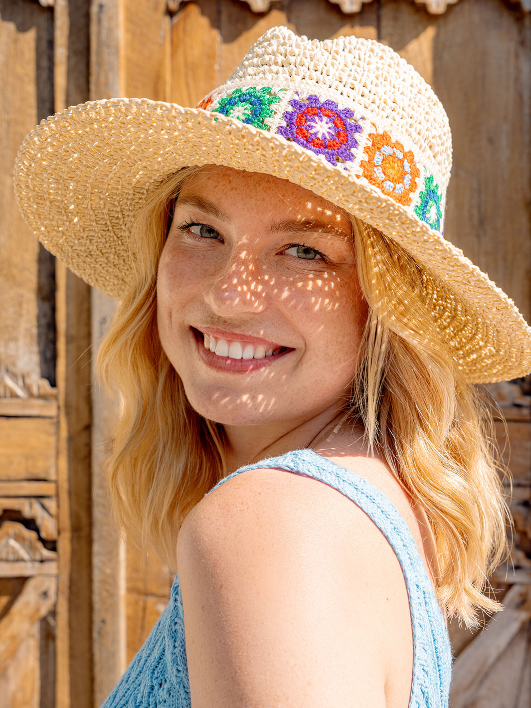 Foto einer lächelnden Frau, die den Loevenich Fedora mit buntem Boho-Muster 674512 trägt.