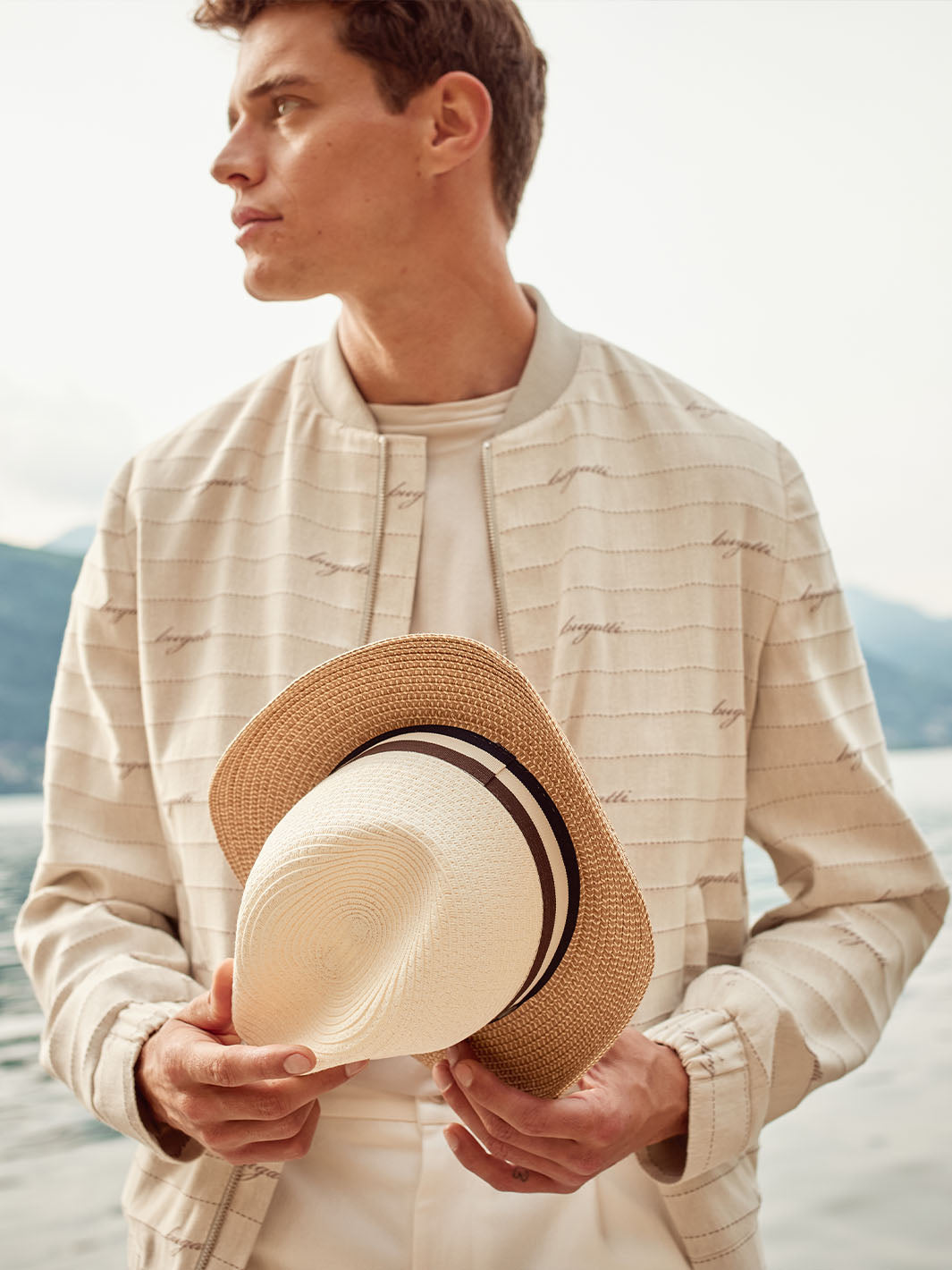 Mann hält einen bugatti Strohhut in der Hand.