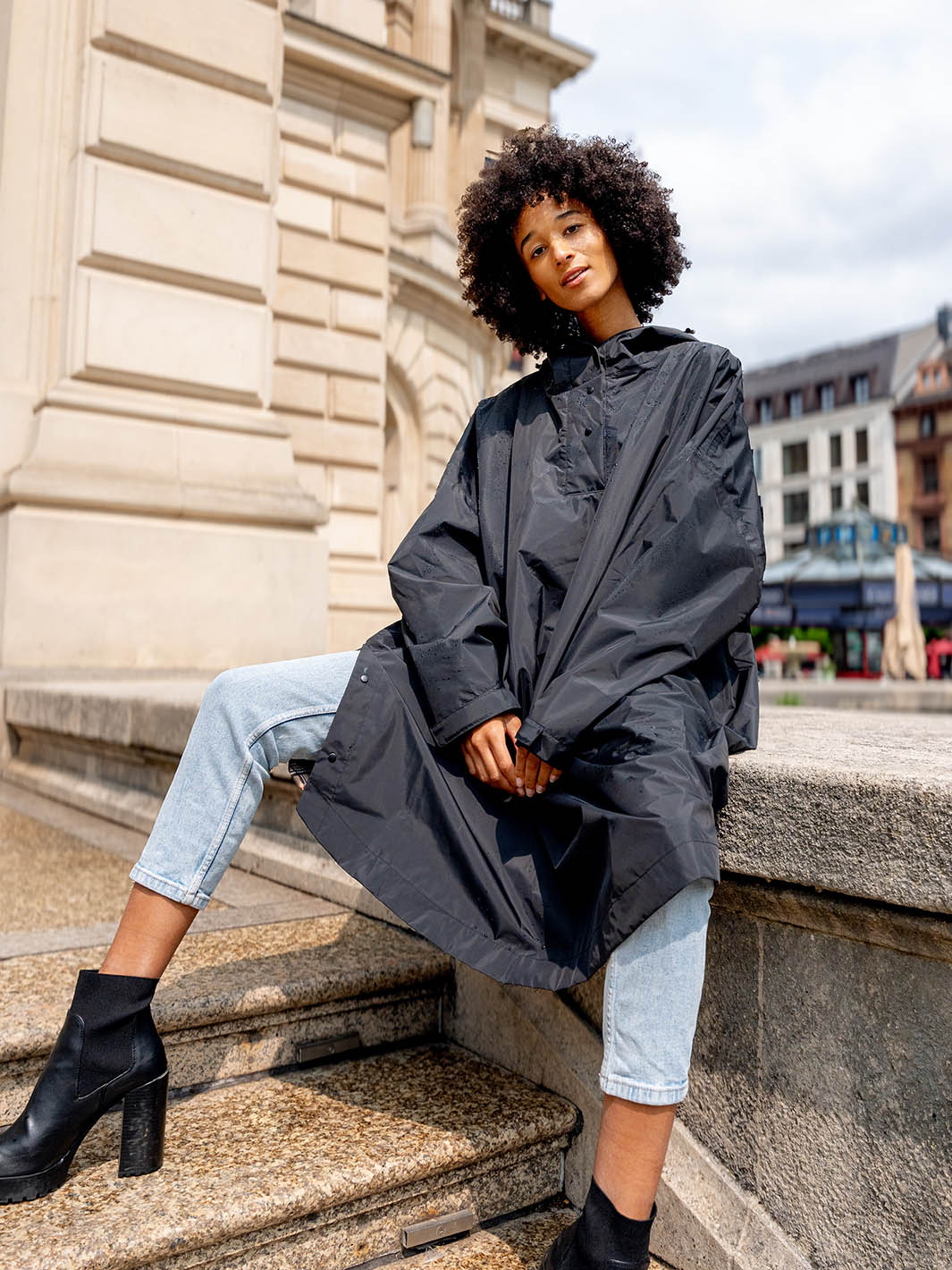 Frau steht auf einer Treppe und trägt den FRAAS Plaid Regen-Poncho 602801