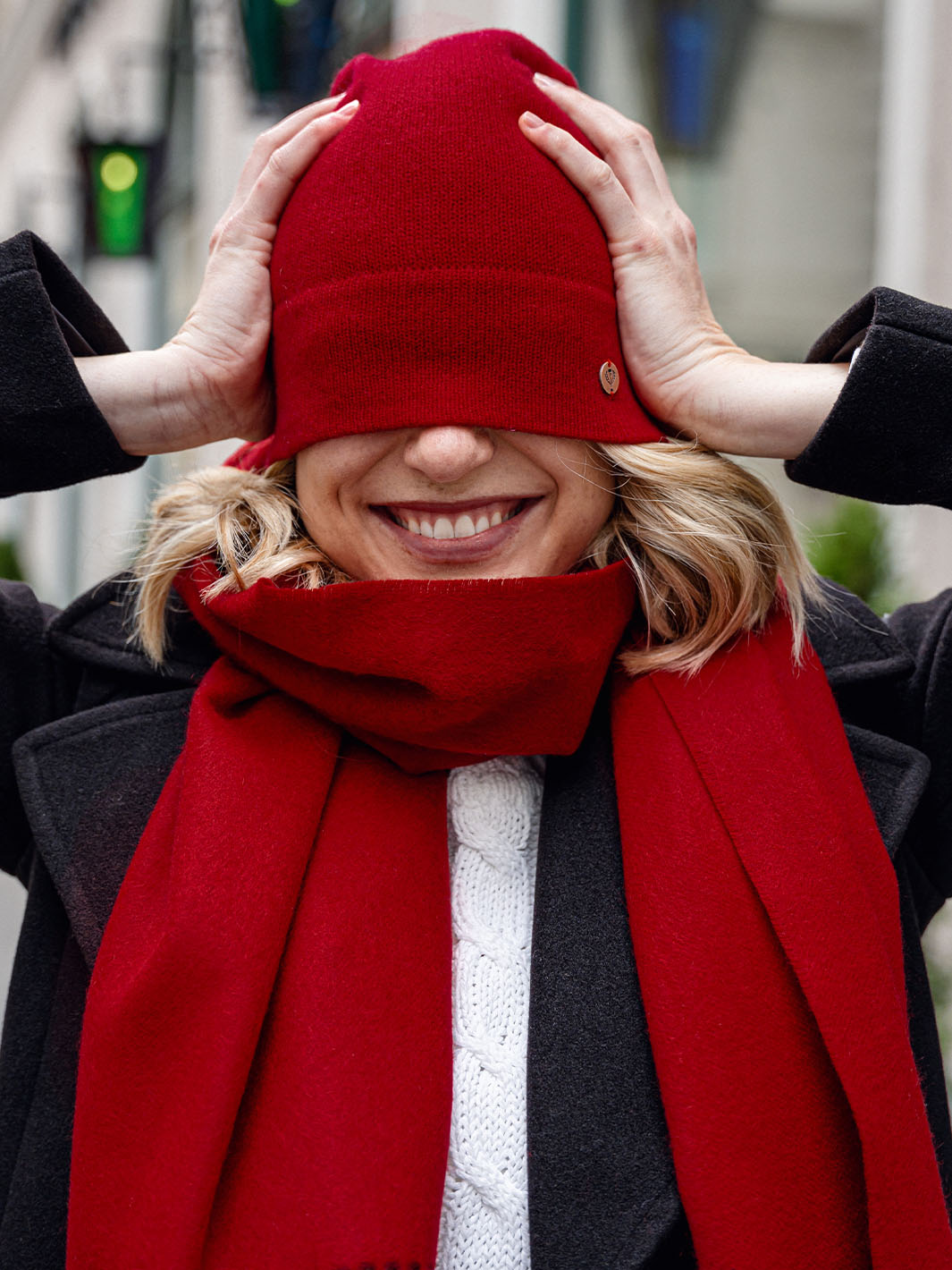Frau hat sich lachend die FRAAS Kaschmirmütze 684304 über die Augen gezogen.